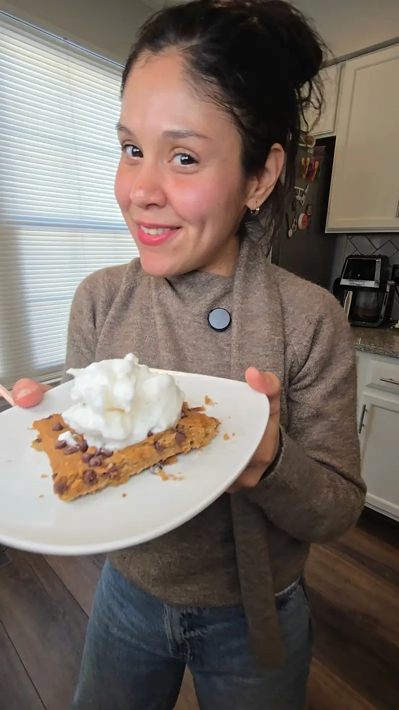 Crystal holding a plate of chickpea blondies topped with aquafaba whipped cream