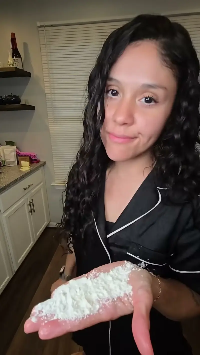 Crystal holding a handful of flour and powdered sugar up to the camera
