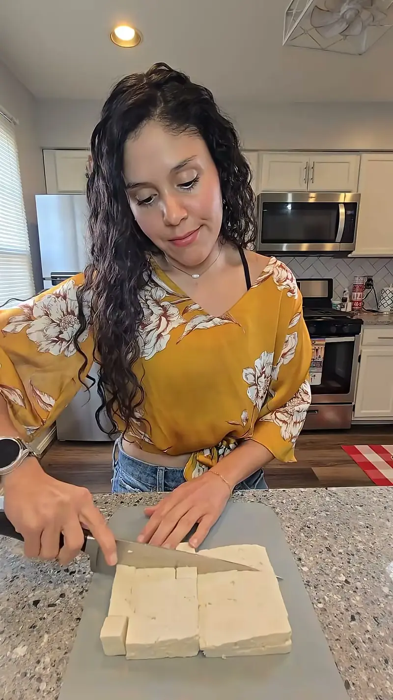 Crystal slicing tofu at her kitchen counter