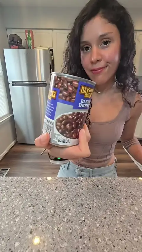 Crystal holding up a can of black beans to the camera