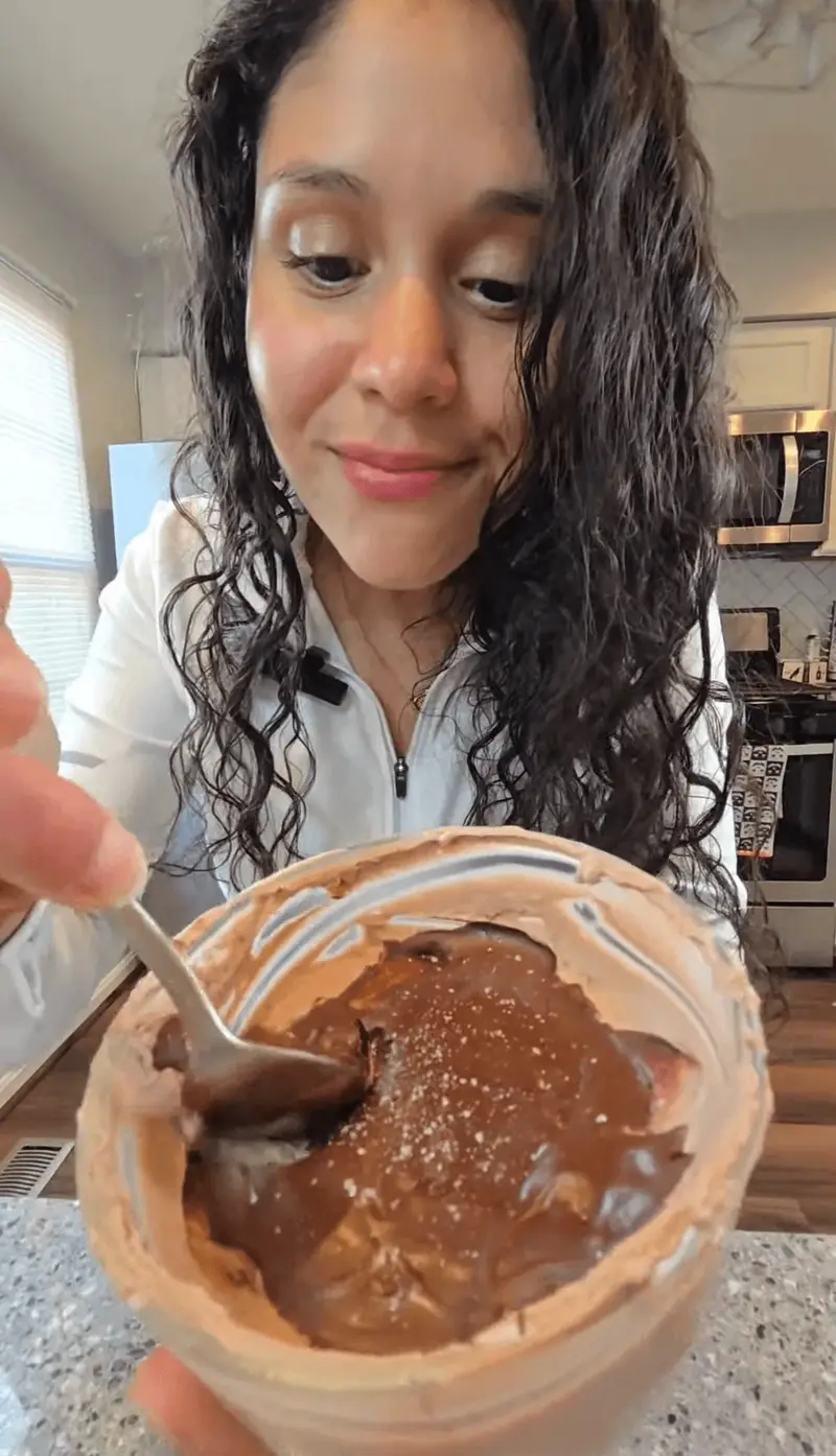 Crystal spooning into a jar of chocolate protein mug pie