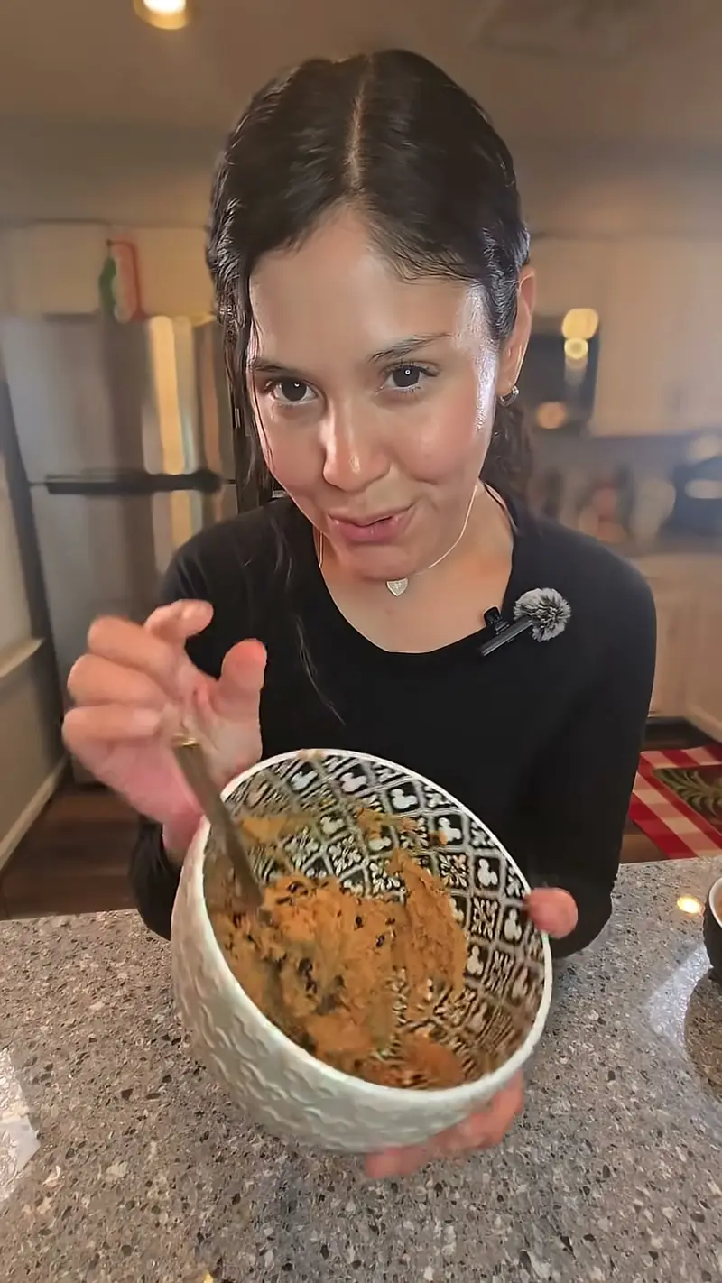 Crystal holding a bowl of chocolate chip protein cookie dough with a spoon in it