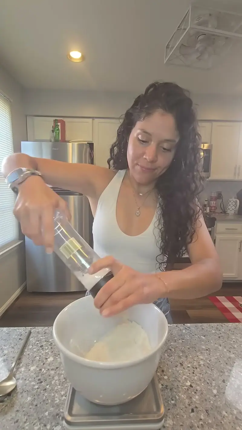 Crystal weighing Greek yogurt into a bowl on the kitchen scale