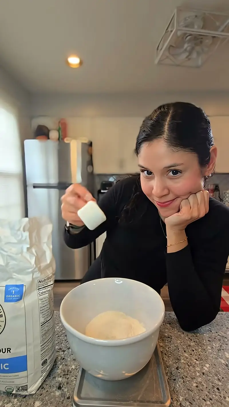 Crystal resting her chin on her hand beside a bowl of flour on the scale