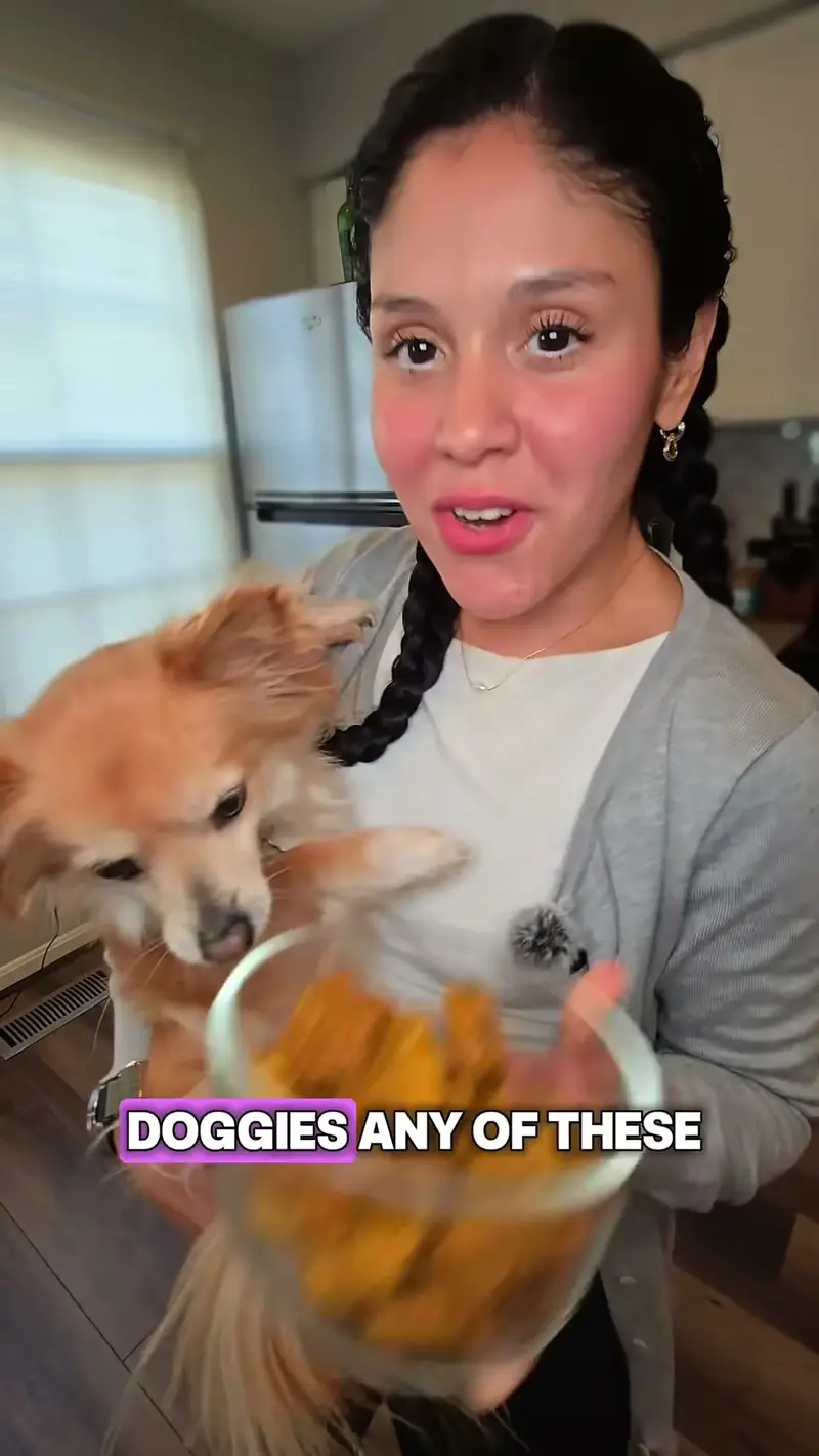 Crystal offering the bowl of treats to her dog, who leans in to sniff
