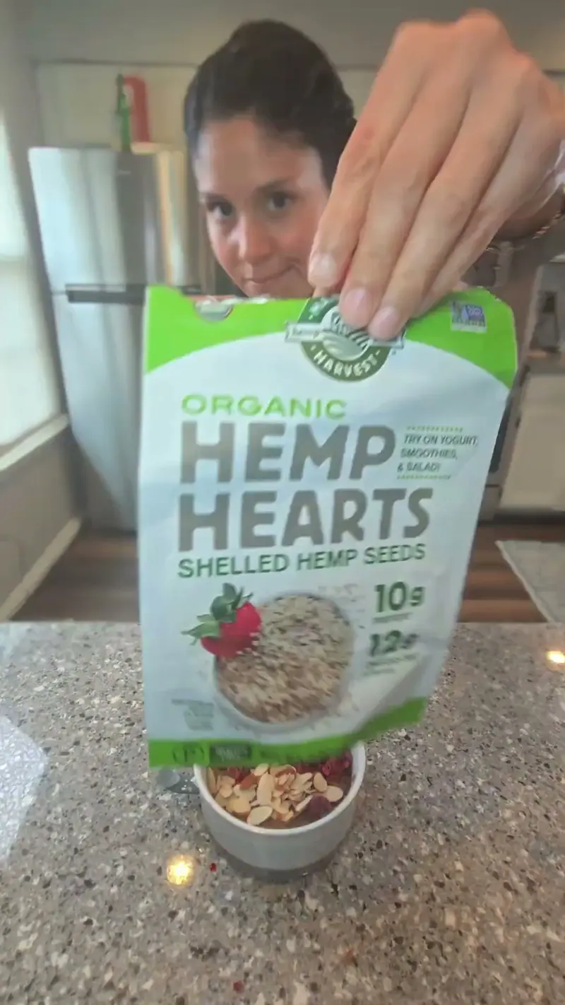 Crystal holding a bag of organic hemp hearts over the finished bowl