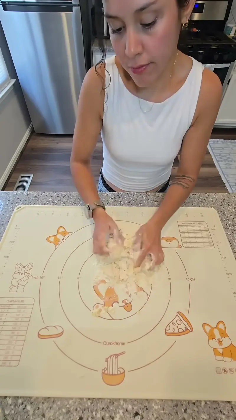 Crystal spooning ricotta filling onto a sheet of fresh pasta dough