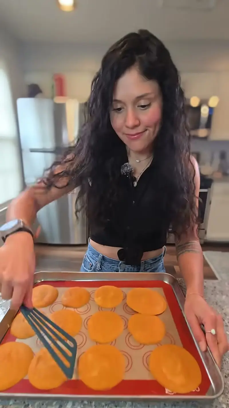 Crystal smoothing the rounds of pumpkin filling flat with a spatula