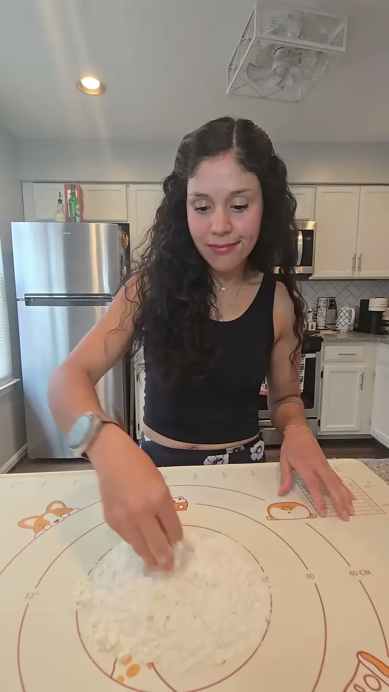 Crystal working a mound of flour on the pastry mat to start the dough