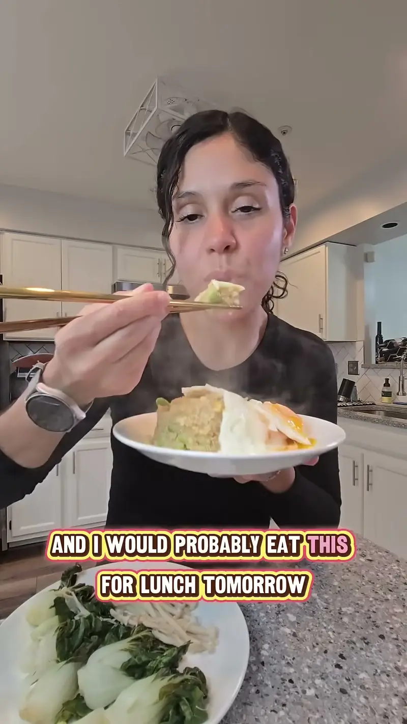 Crystal eating a bite of the quinoa bowl with chopsticks, steamed greens beside her