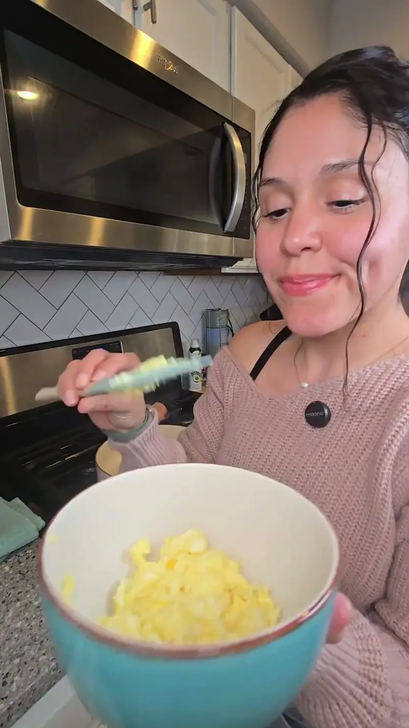 Crystal holding a teal bowl of scrambled egg ready for the fried rice