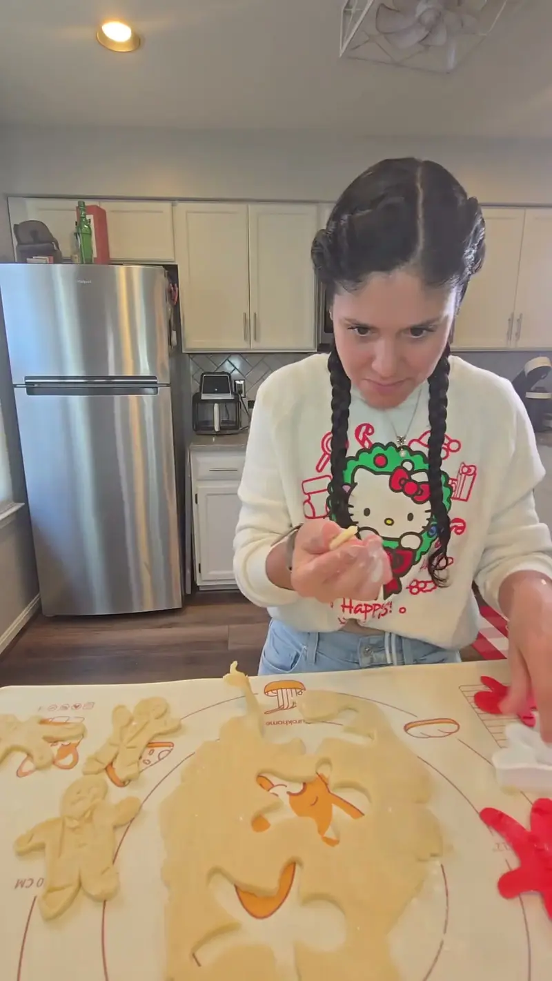Crystal cutting gingerbread shapes out of the rolled shortbread dough