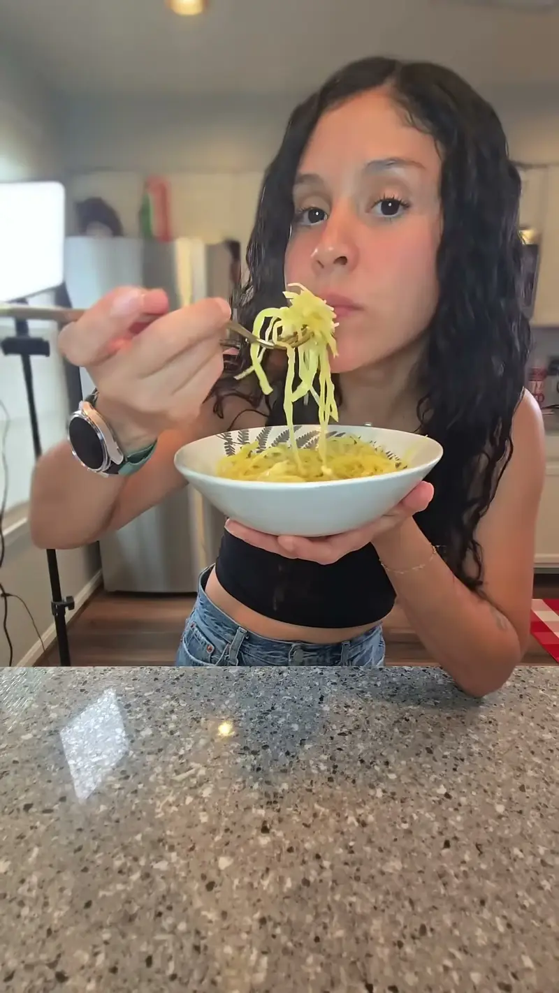 Crystal lifting cabbage noodles out of a bowl with a fork