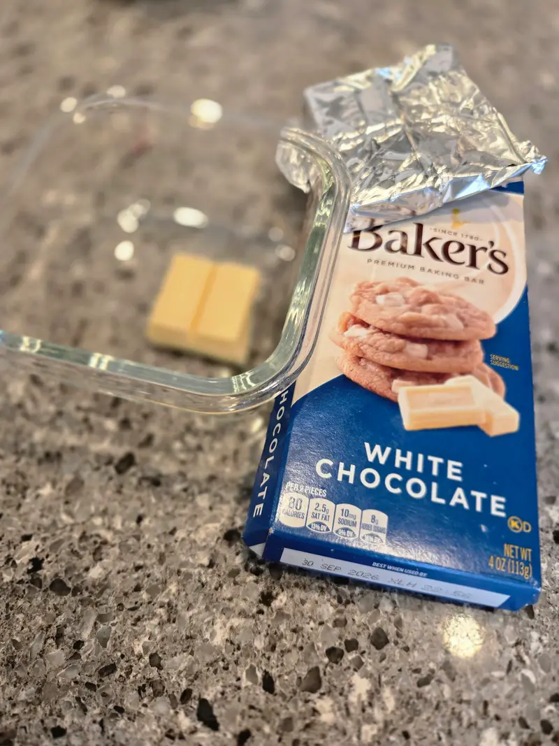 A box of Baker's white chocolate with two squares set out on the counter