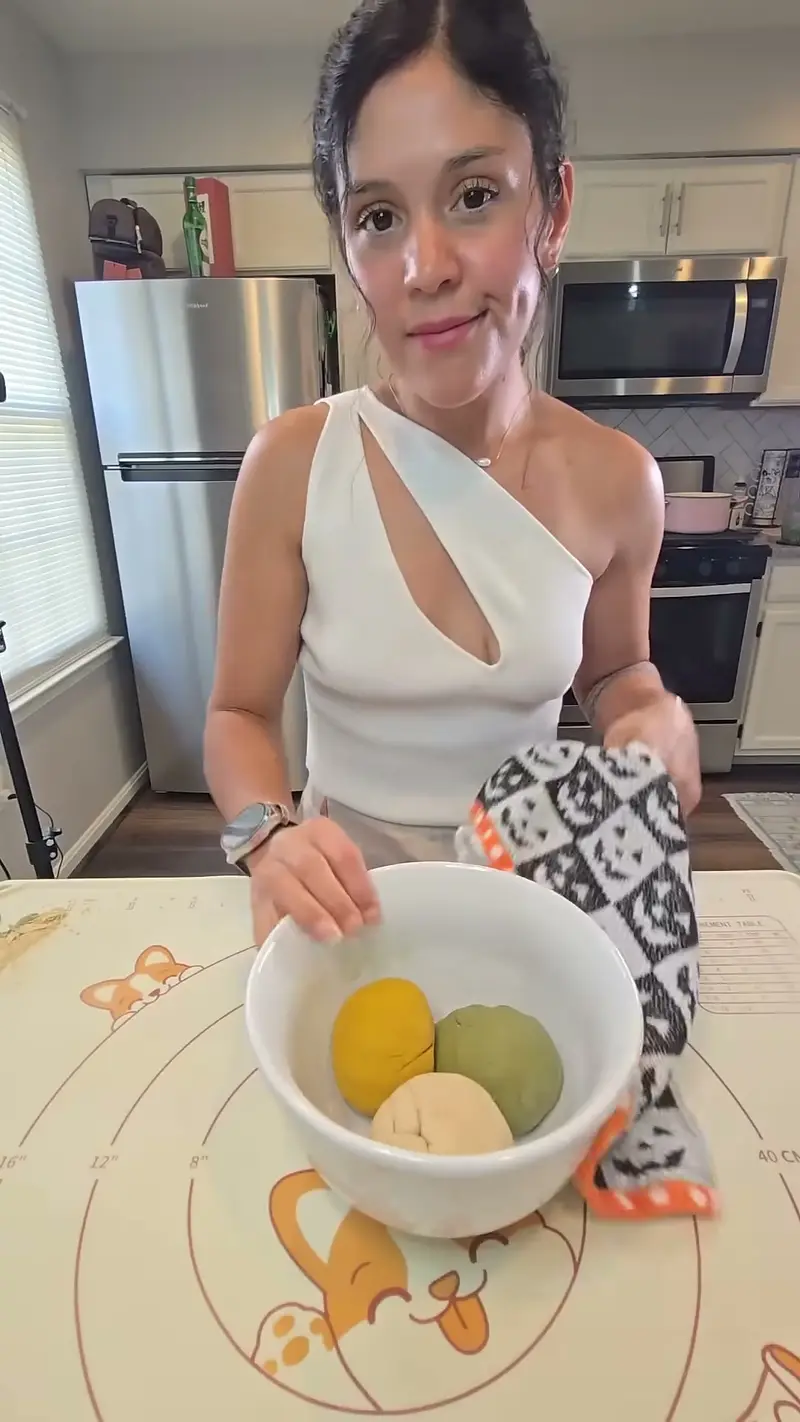 Crystal holding a bowl with three balls of dough - yellow, green and plain